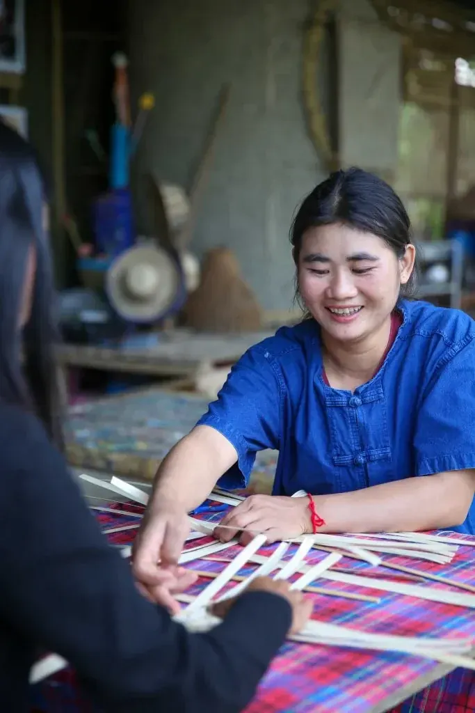 A person weaving a bamboo fan