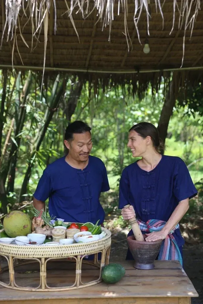 A foreign adult guest and a Thai host enjoying Northern Thai cooking